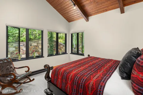 a bedroom with a bed and windows