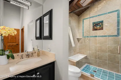 a bathroom with a sink a toilet and mirror