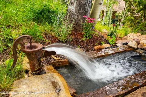 a front view of a house with a yard and fountain
