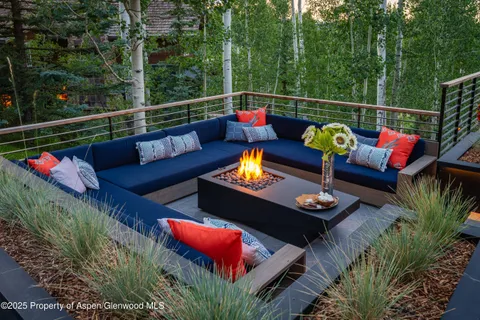 an outdoor living room with furniture and garden view