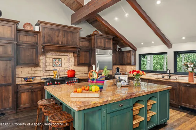 a kitchen with stainless steel appliances granite countertop a sink a stove and a wooden floors