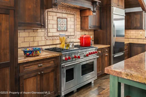 a kitchen with stainless steel appliances granite countertop a stove and a refrigerator