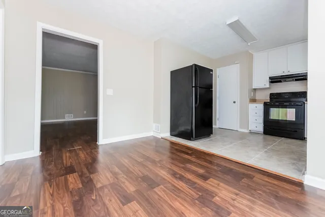 a view of a kitchen with wooden floor and a refrigerator