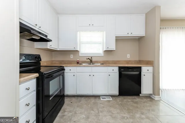 a kitchen with stainless steel appliances granite countertop a sink stove and cabinets
