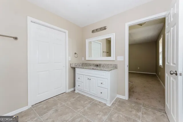 a bathroom with a granite countertop sink and a mirror