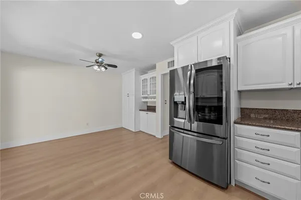 a kitchen with granite countertop stainless steel appliances a refrigerator and cabinets