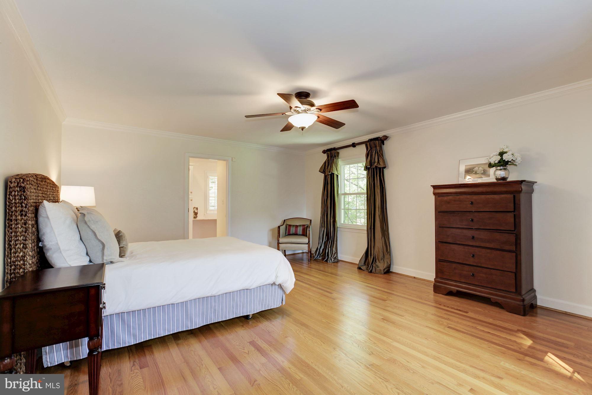 5509 Center Street Chevy Chase, MD 20815 - Photo 14 of 30 a bedroom with a bed next to a window and a chandelier