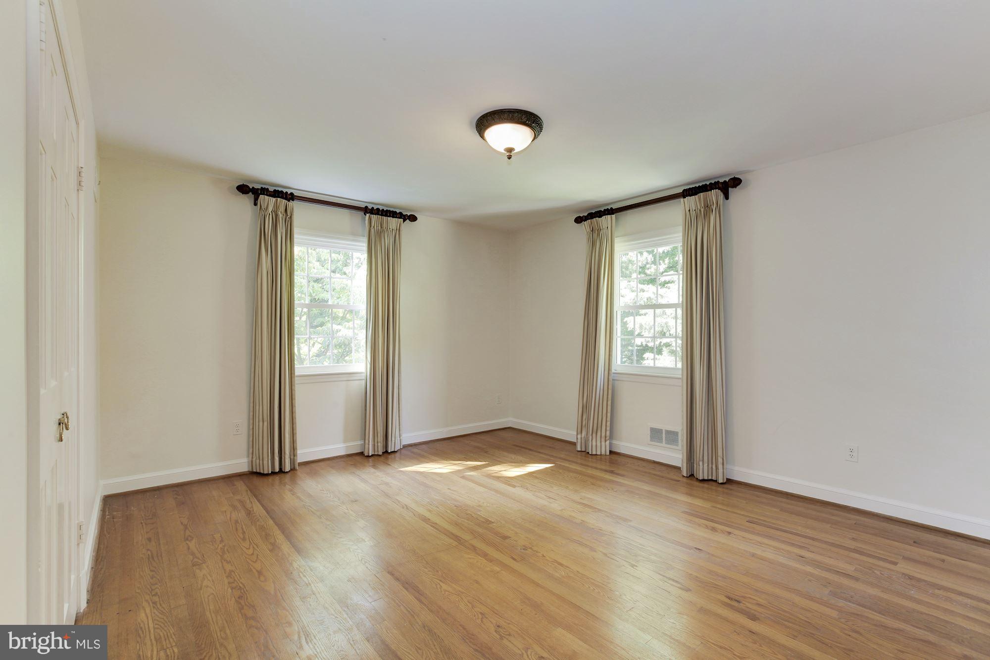 5509 Center Street Chevy Chase, MD 20815 - Photo 19 of 30 an empty room with wooden floor and windows