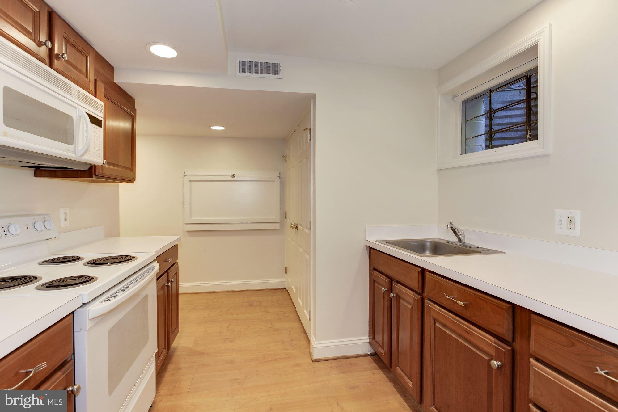 5509 Center Street Chevy Chase, MD 20815 - Photo 23 of 30 a kitchen with a sink stove and cabinets