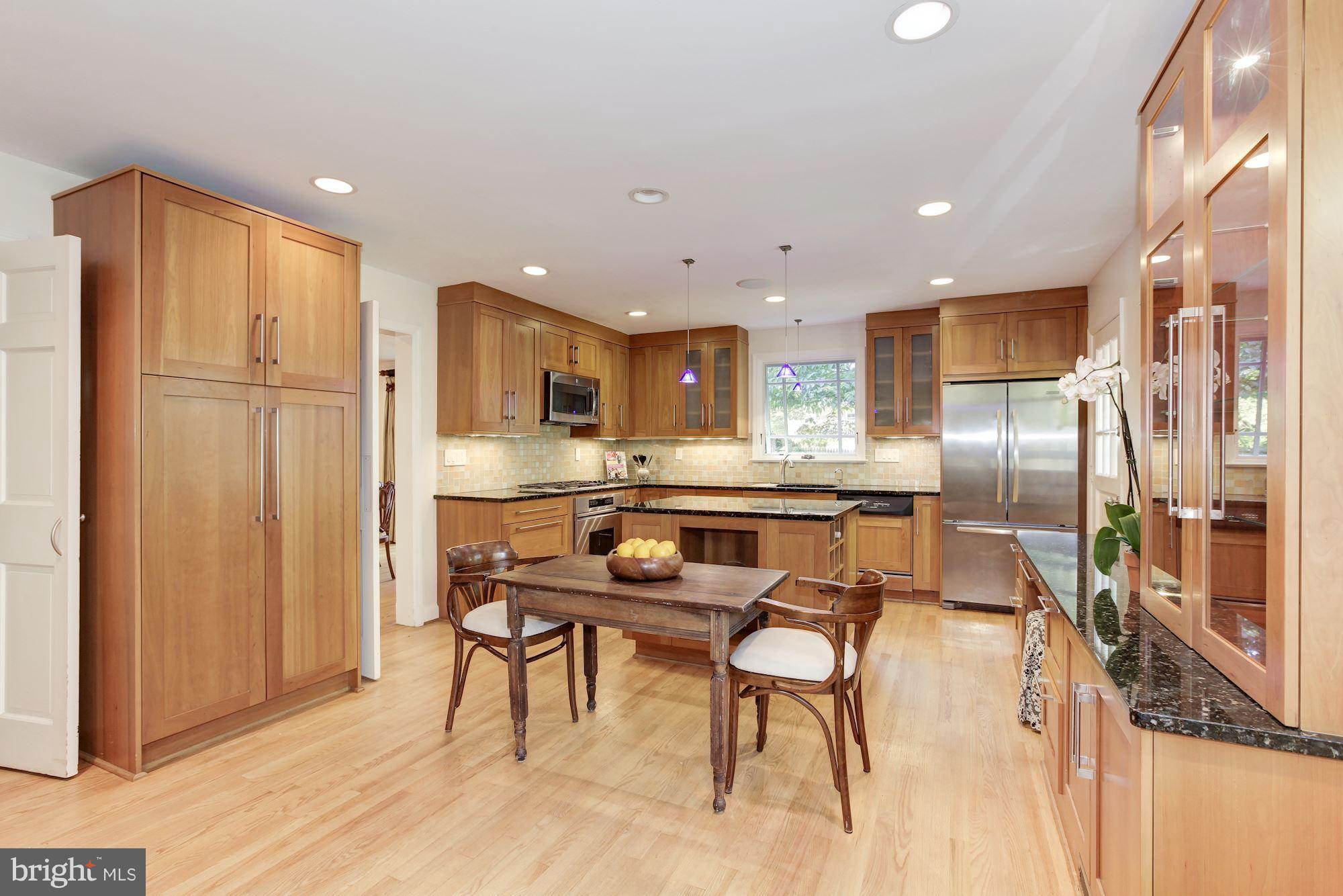 5509 Center Street Chevy Chase, MD 20815 - Photo 7 of 30 a kitchen with stainless steel appliances kitchen island granite countertop a refrigerator and microwave