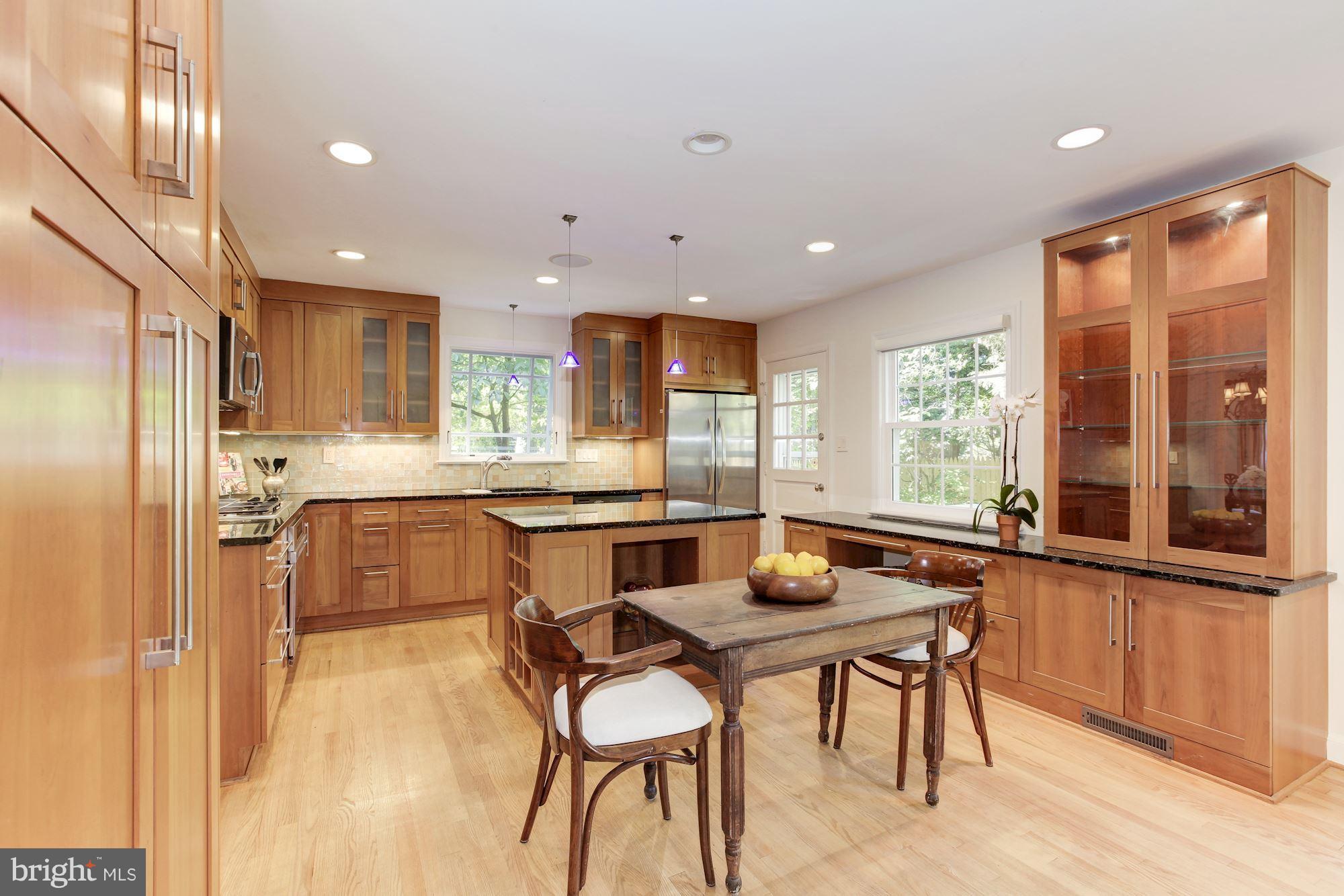 5509 Center Street Chevy Chase, MD 20815 - Photo 8 of 30 a kitchen with a table chairs refrigerator and microwave