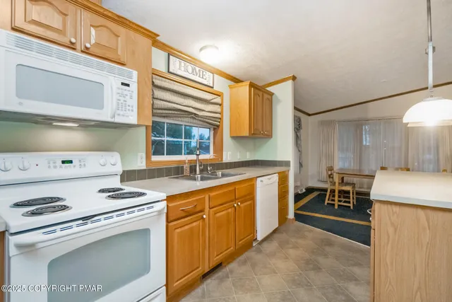a kitchen with stainless steel appliances granite countertop a sink and a refrigerator