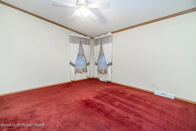 an empty room with a ceiling fan and a window