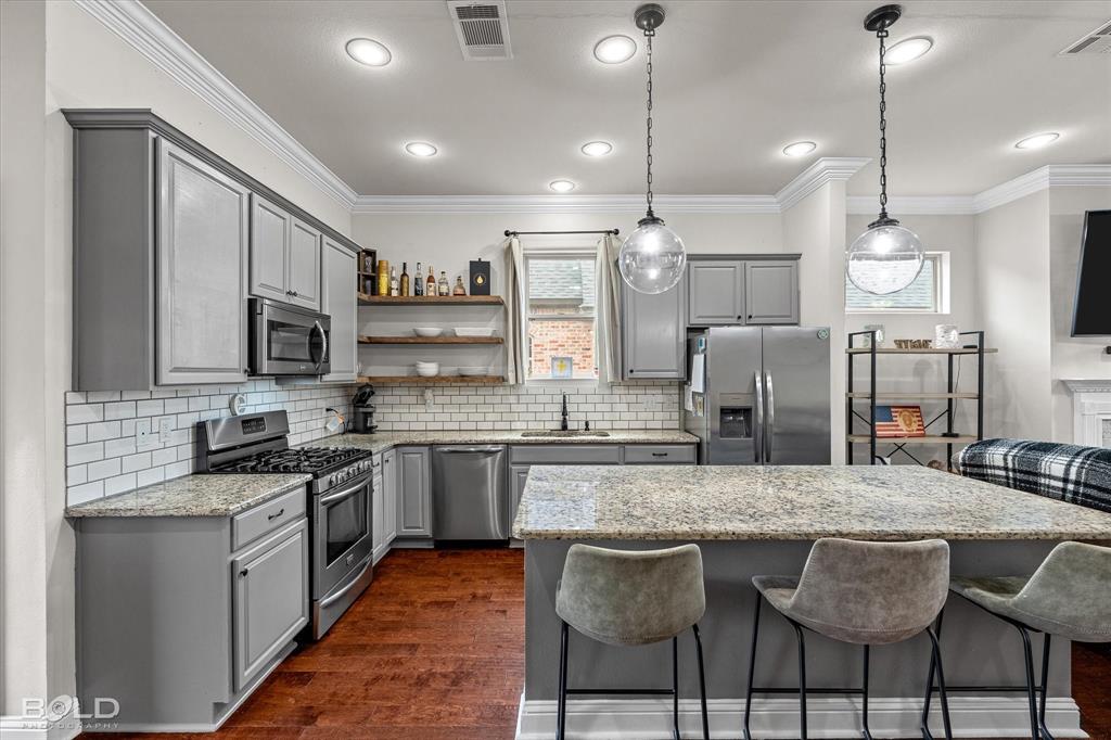 946 Maize Street Bossier City, LA 71111 - Photo 20 of 39 a kitchen with stainless steel appliances granite countertop a stove top oven a sink dishwasher a dining table and chairs