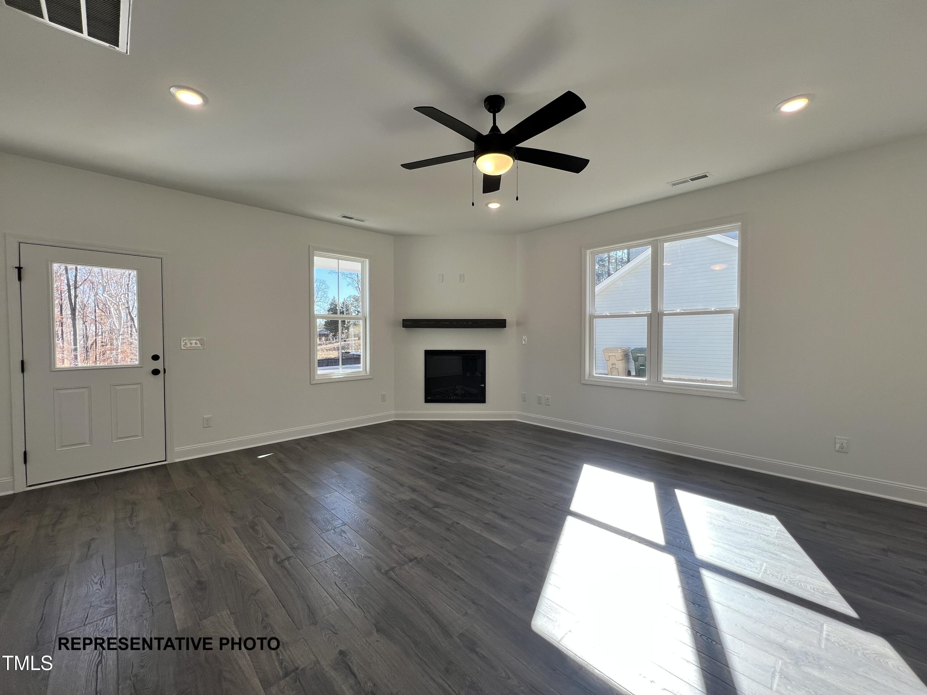 532 Springtooth Drive Zebulon, NC 27597 - Photo 4 of 8 a view of an empty room with wooden floor and a window