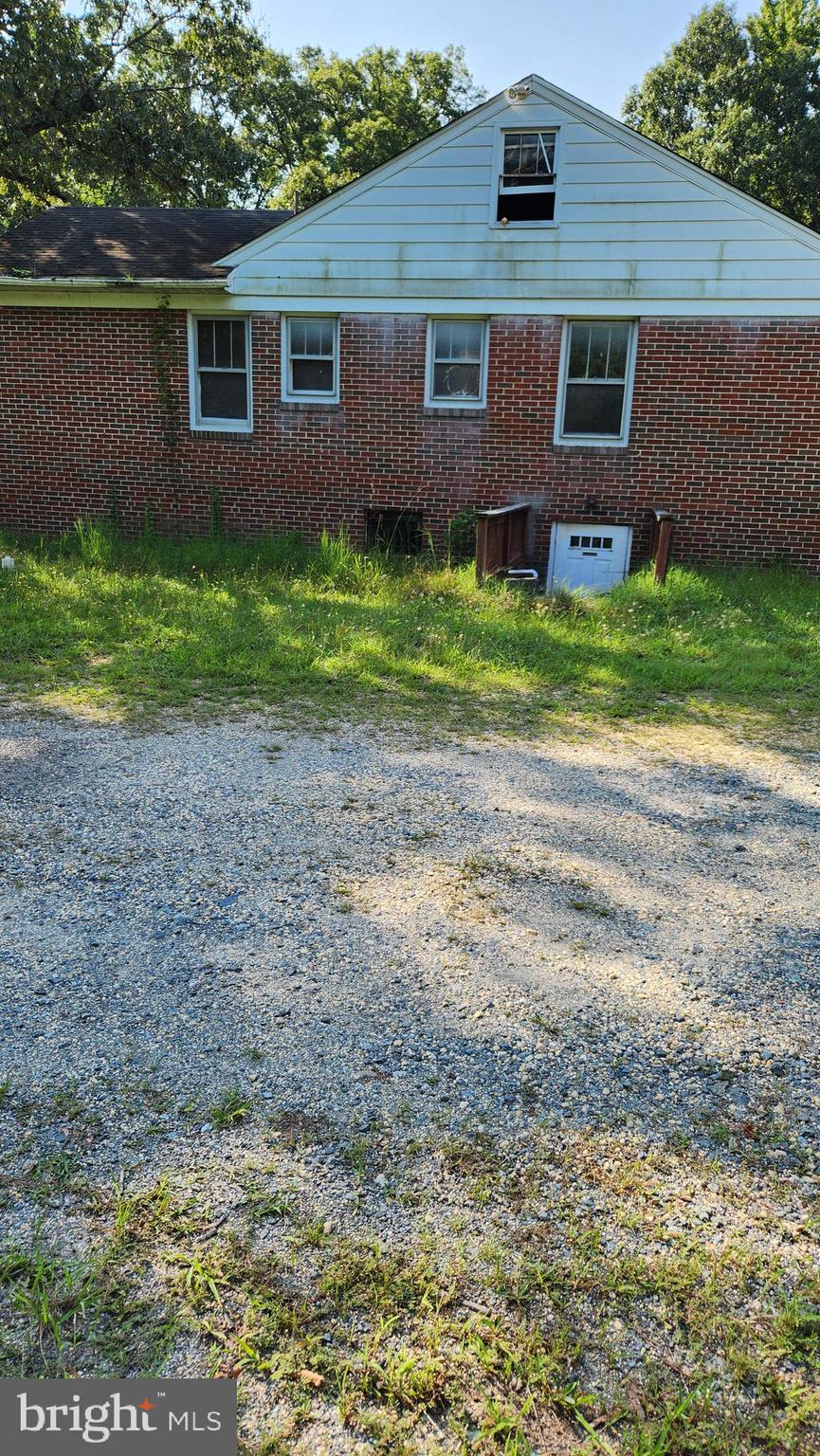 4499 Leonardtown Road Waldorf, MD 20601 - Photo 7 of 11 a view of a yard in front of a brick house with large windows