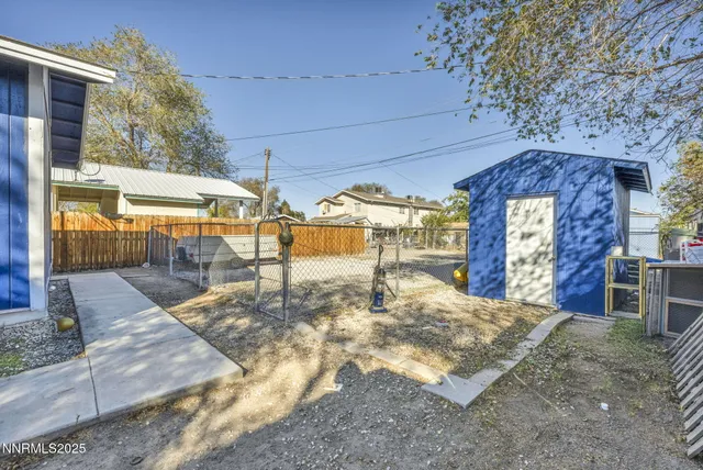 a view of a house with a yard and wooden fence