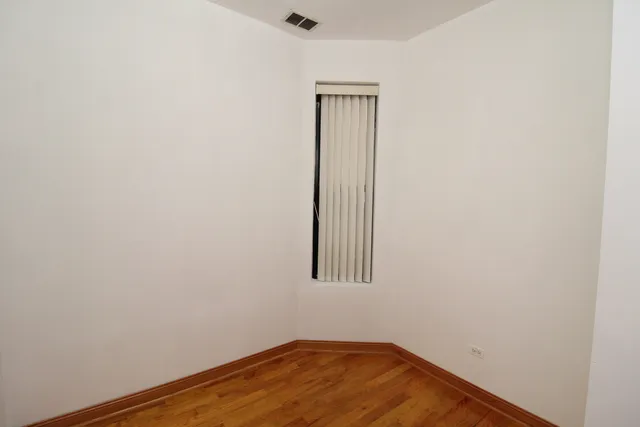 a view of small space with wooden floor and a window