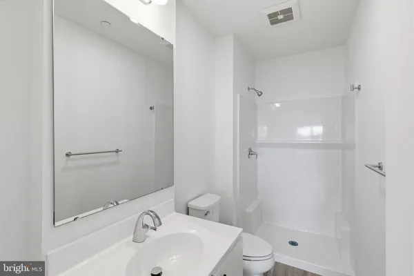 a bathroom with a bathtub shower sink vanity and toilet