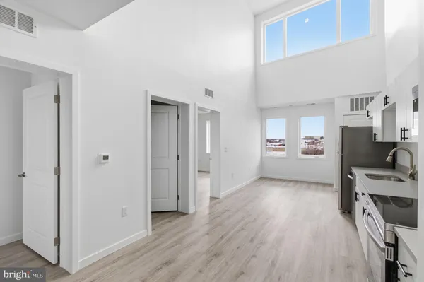a view of a kitchen and an entryway with wooden floor