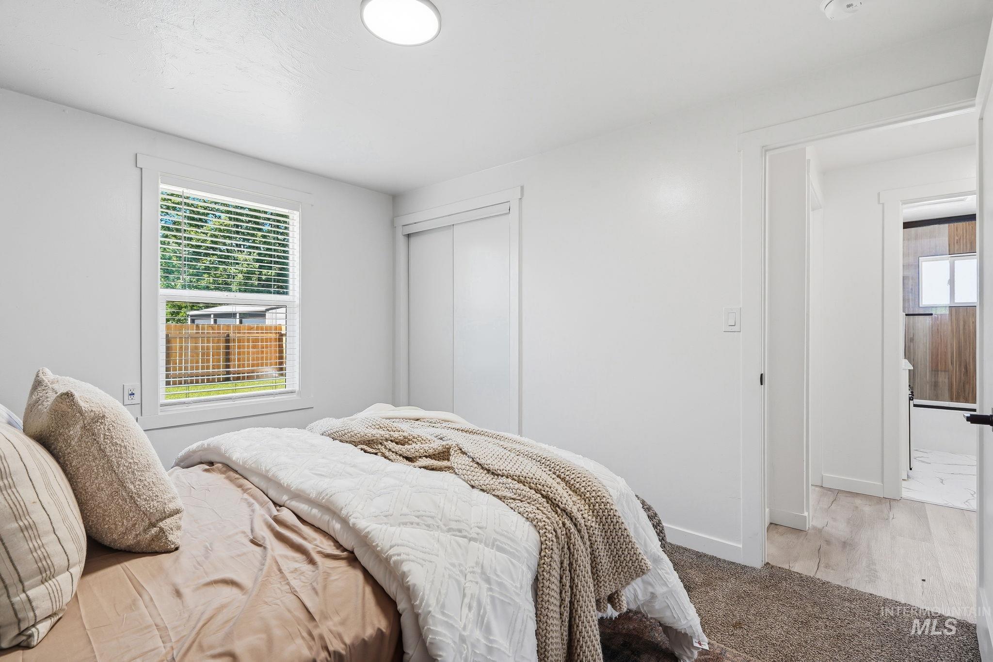 2152 Artesian Road Eagle, ID 83616 - Photo 23 of 50 Bedroom featuring a window with privacy blinds, white trim, and a built-in sliding closet