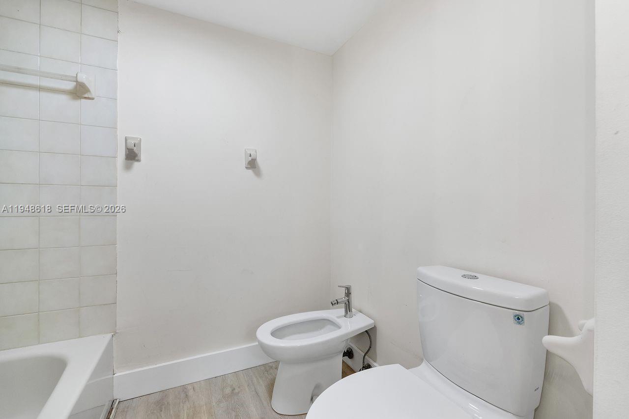 995 Southwest 84th Avenue, Unit 223 Miami, FL 33144 - Photo 14 of 25 a white toilet sitting next to a bath tub