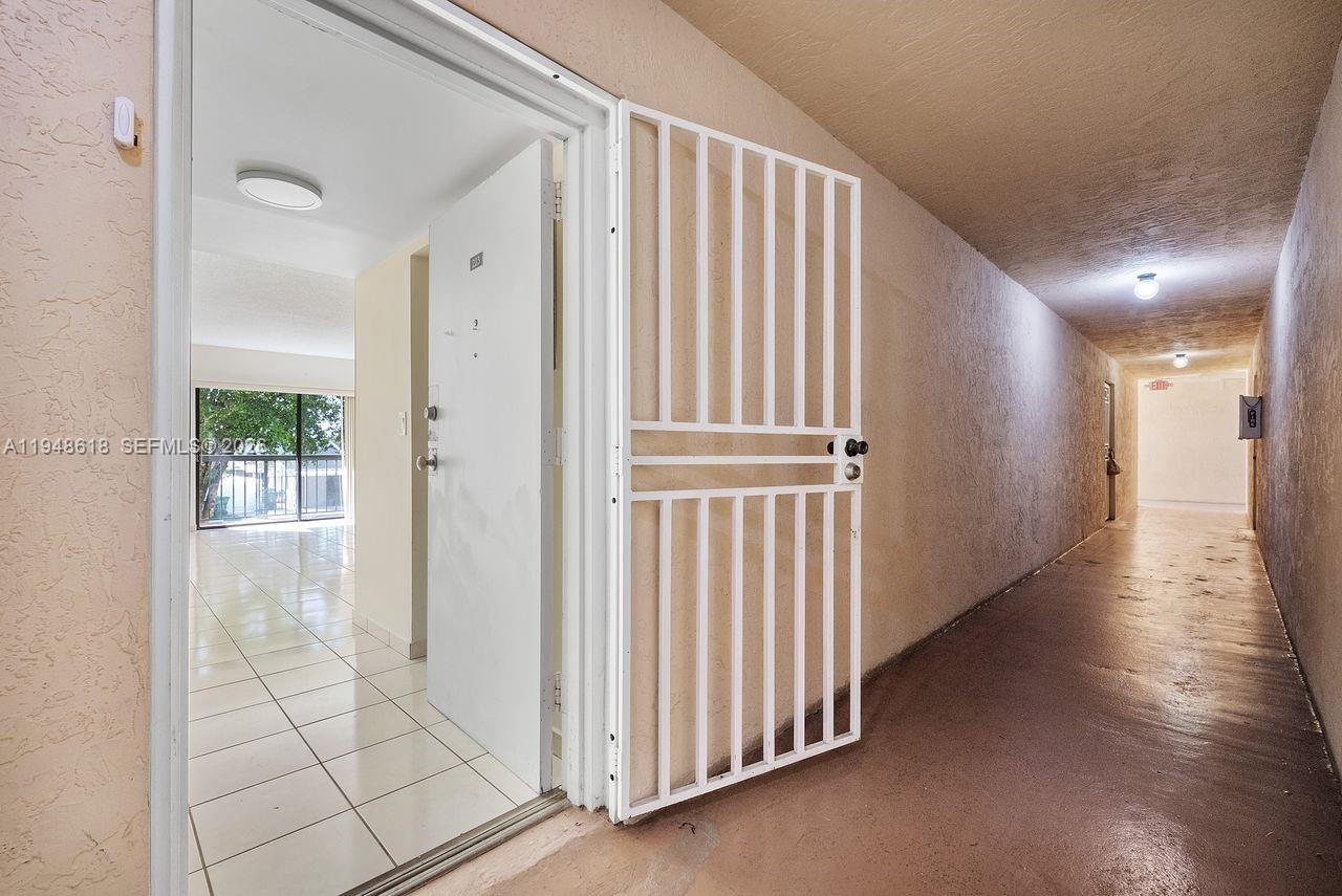995 Southwest 84th Avenue, Unit 223 Miami, FL 33144 - Photo 23 of 25 a view of a hallway with wooden floor and staircase