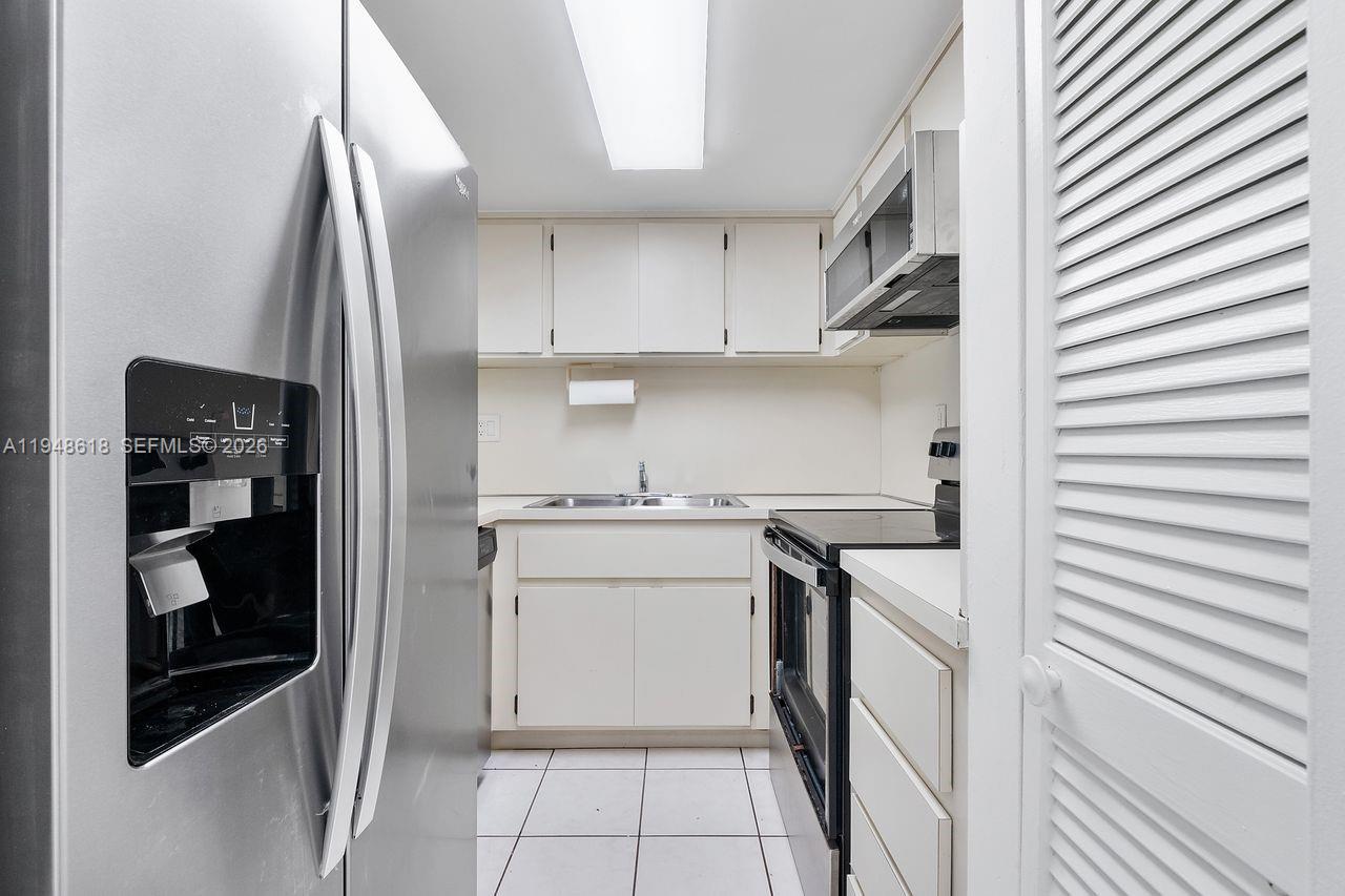 995 Southwest 84th Avenue, Unit 223 Miami, FL 33144 - Photo 5 of 25 a kitchen with a sink and a refrigerator