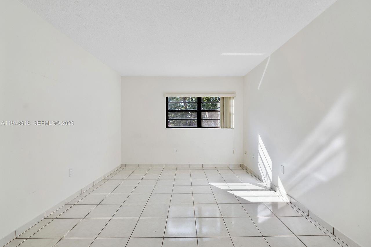 995 Southwest 84th Avenue, Unit 223 Miami, FL 33144 - Photo 9 of 25 an empty room with white walls and tiles