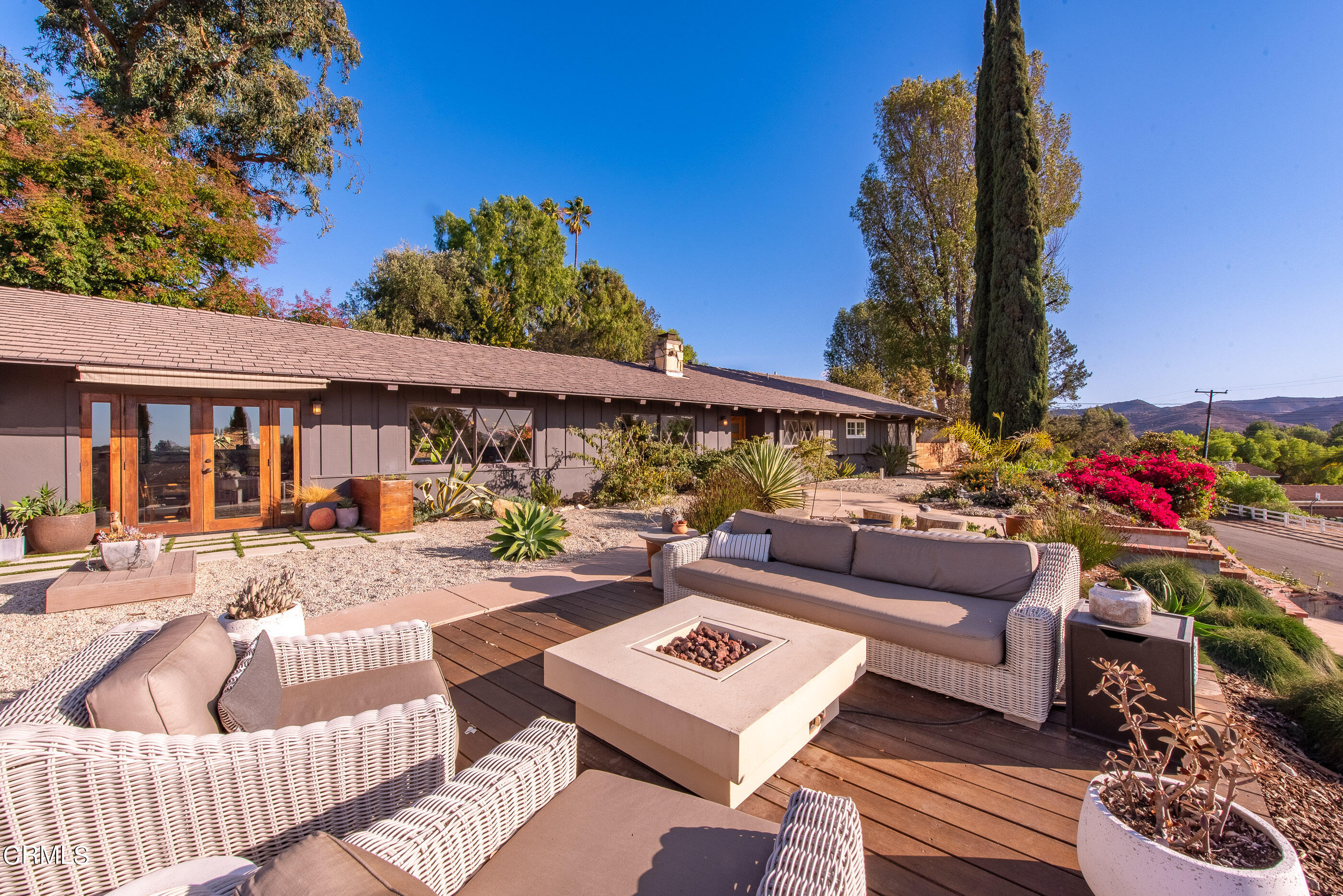 a view of a patio with couches table and chairs and potted plants