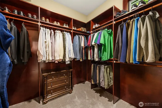 a view of walk in closet with clothes and shoes