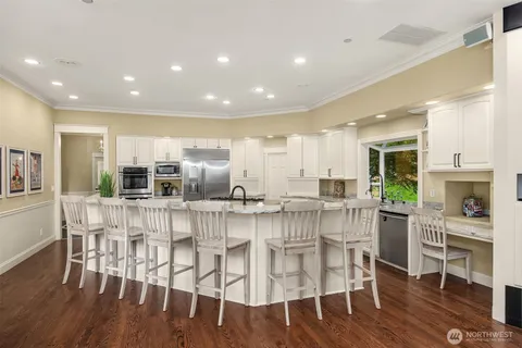 a kitchen with stainless steel appliances kitchen island granite countertop a dining table chairs and granite counter tops