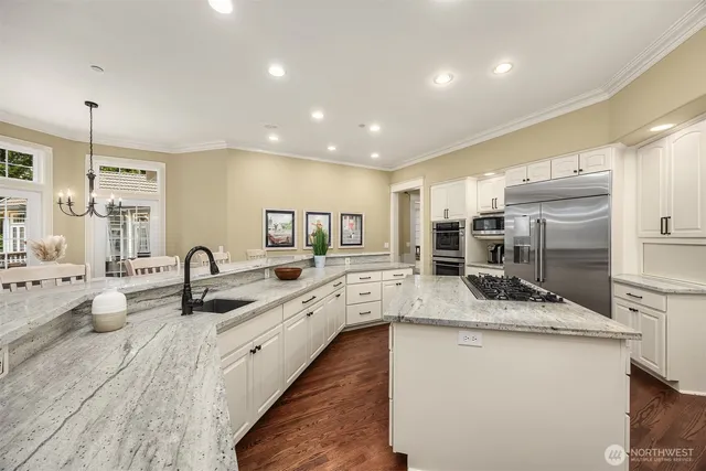 a large kitchen with granite countertop a sink and a stove top oven