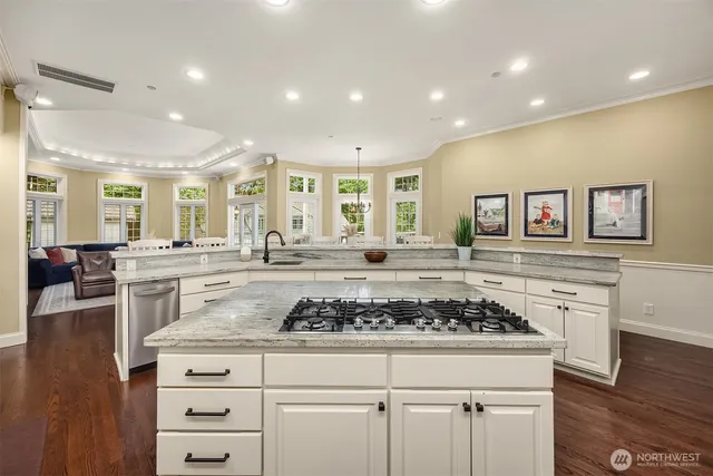 a kitchen with stainless steel appliances granite countertop a stove and white cabinets