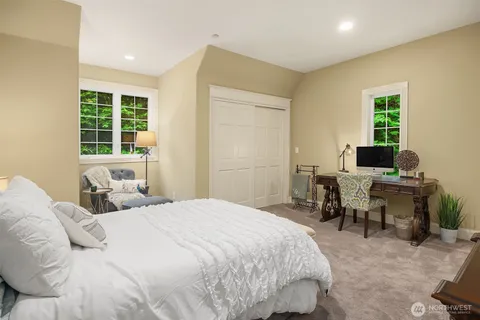 a bedroom with a bed and large windows