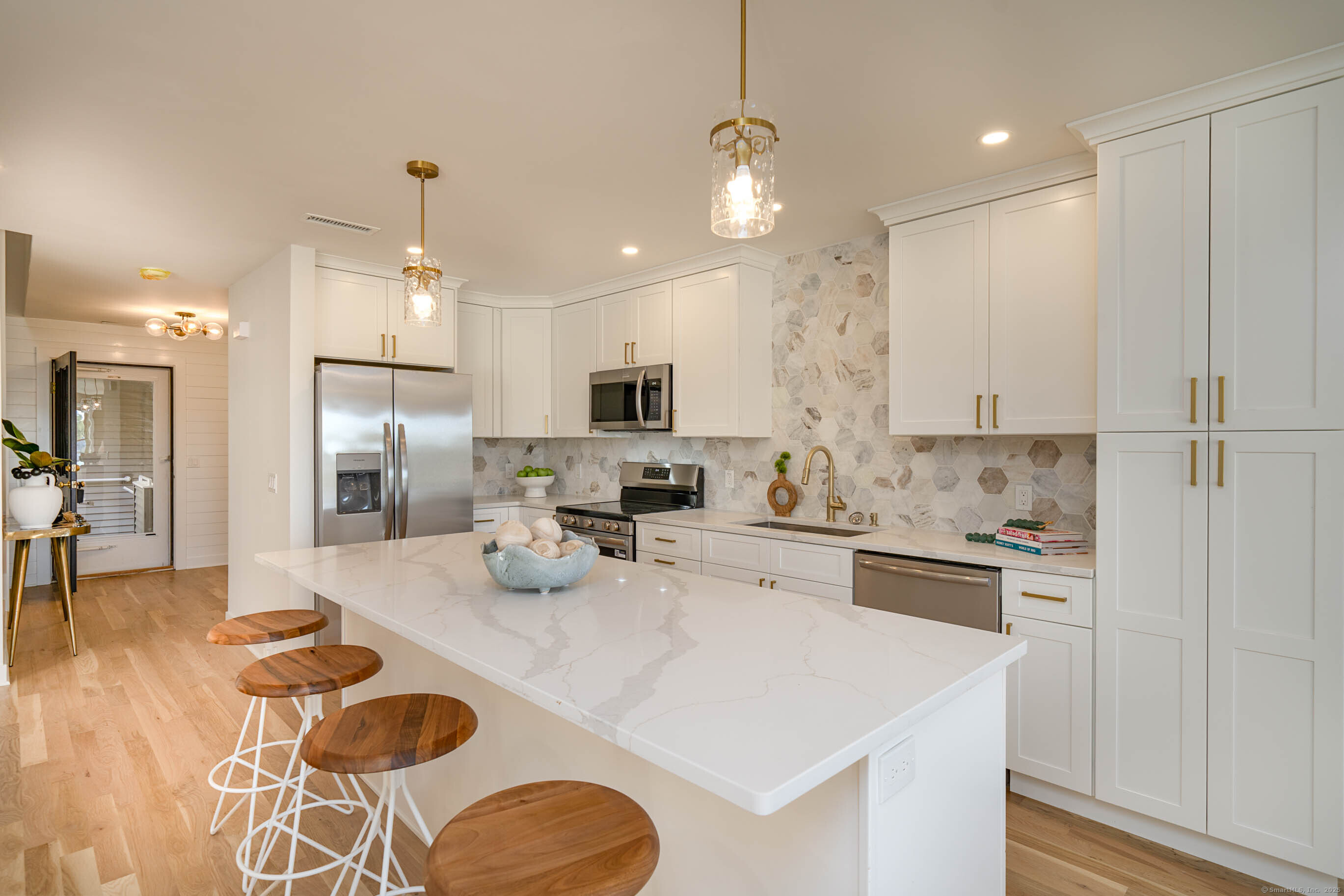 74 Quarry Dock Road, Unit 74 Branford, CT 06405 - Photo 14 of 37 a kitchen with a refrigerator a stove a sink and white cabinets with wooden floor