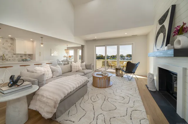 a living room with furniture a fireplace and a large window