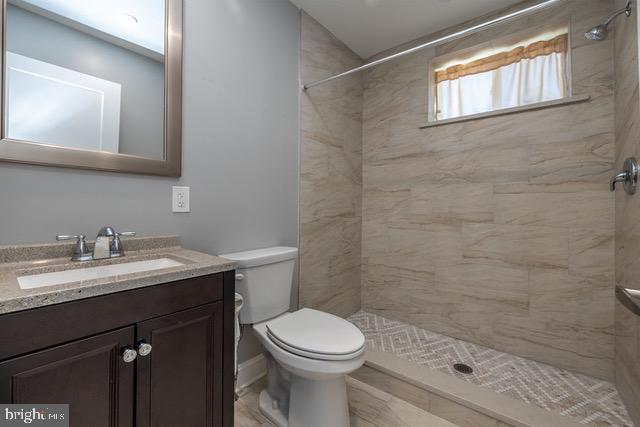 512 Jessamine Avenue Oaklyn, NJ 08107 - Photo 11 of 25 a bathroom with a granite countertop toilet a sink a mirror and a shower