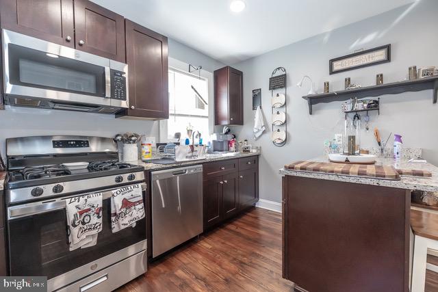 512 Jessamine Avenue Oaklyn, NJ 08107 - Photo 25 of 25 a kitchen with stainless steel appliances wooden cabinets and a stove top oven