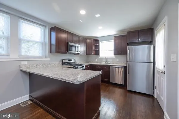 a kitchen with a refrigerator a microwave a sink and a stove