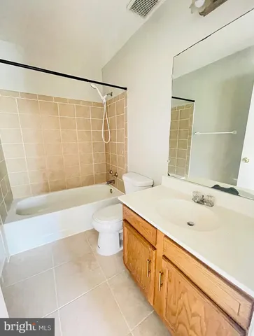 a bathroom with a granite countertop sink a toilet and bathtub
