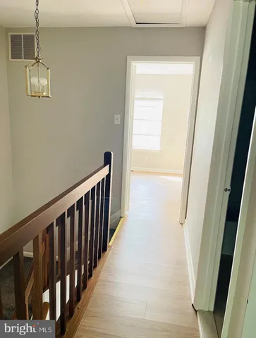 a view of a hallway with wooden floor and staircase