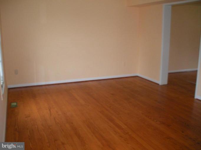 7012 Glen Spring Road Windsor Mill, MD 21244 - Photo 2 of 15 a view of an empty room with wooden floor and a window