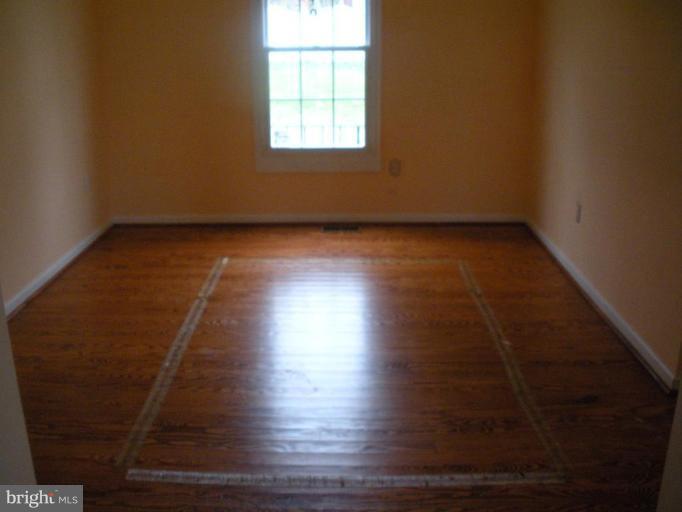 7012 Glen Spring Road Windsor Mill, MD 21244 - Photo 4 of 15 an empty room with wooden floor and windows