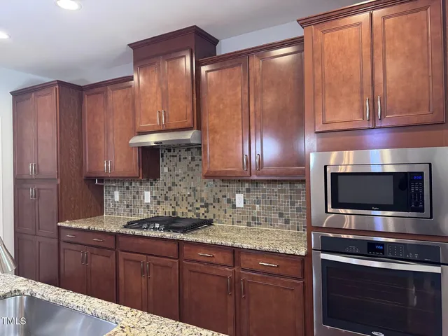 a kitchen with stainless steel appliances wooden cabinets and a sink