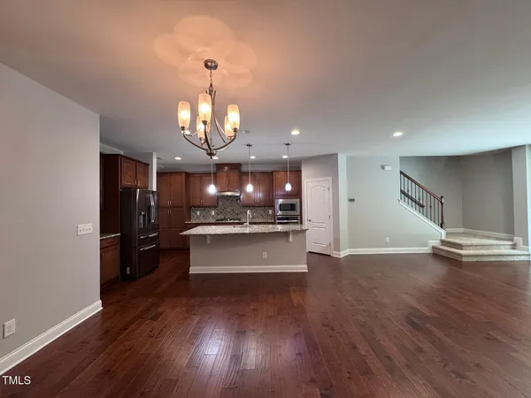 a view of a living room and kitchen with wooden floor