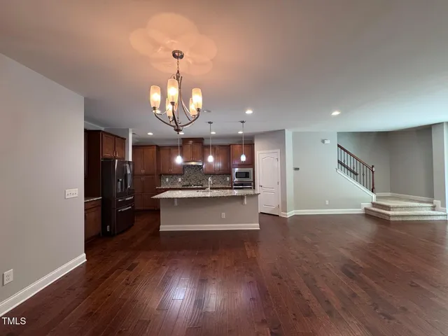 a view of a living room and kitchen with wooden floor