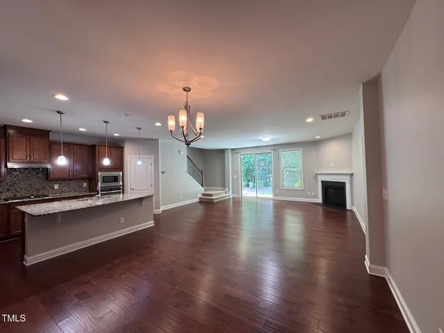 an open kitchen view with wooden floor and a fireplace