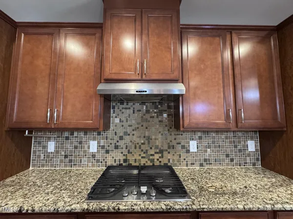 a kitchen with granite countertop cabinets and a stove top oven