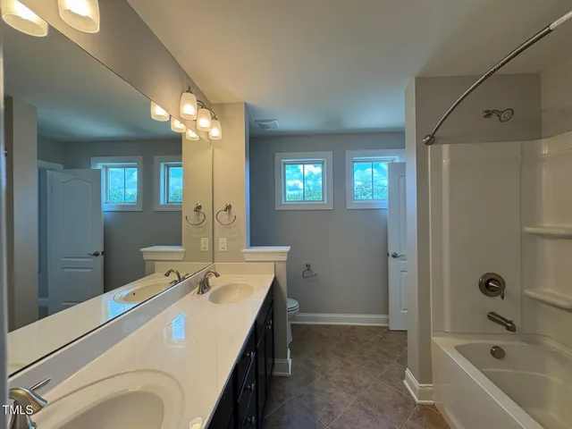 a bathroom with a tub a sink and mirror